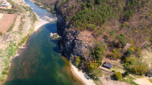 Scenic river flowing beside a cliff