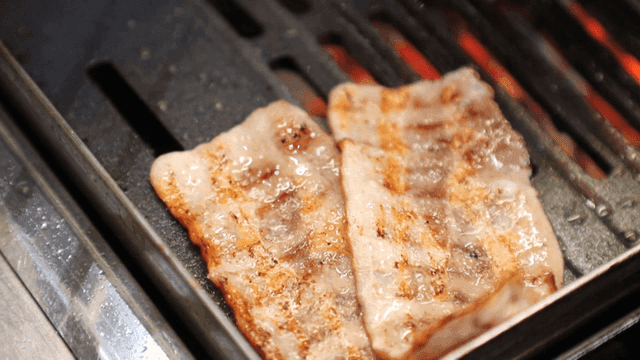 뜨거운 그릴 위에 삼겹살 뒤집는 집게