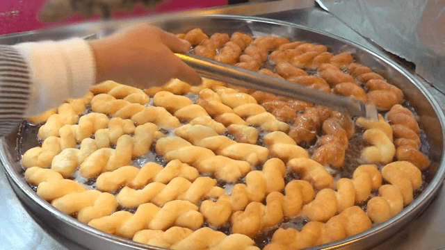 뜨거운 기름에 튀겨지는 꽈배기 도넛