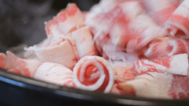 얇게 썬 고기가 팬에서 요리되는 모습