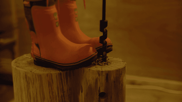 실내에서 나무 통에 드릴 작업