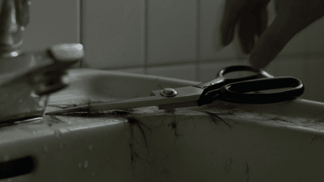 욕실 싱크대 위의 가위와 머리카락