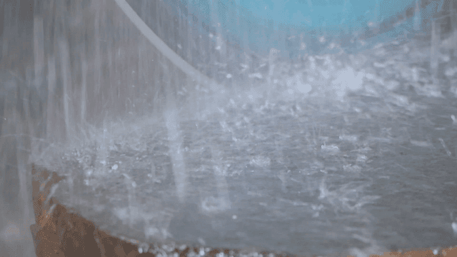 빠르게 회전하며 물이 뿌려지는 대형 돌 절단 톱