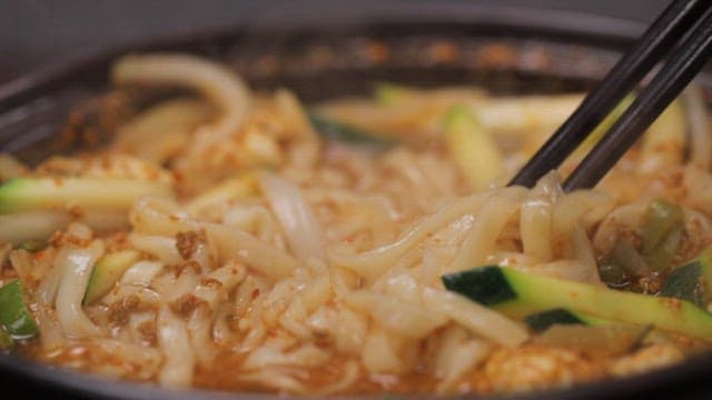 젓가락으로 장칼국수를 들어올리는 장면