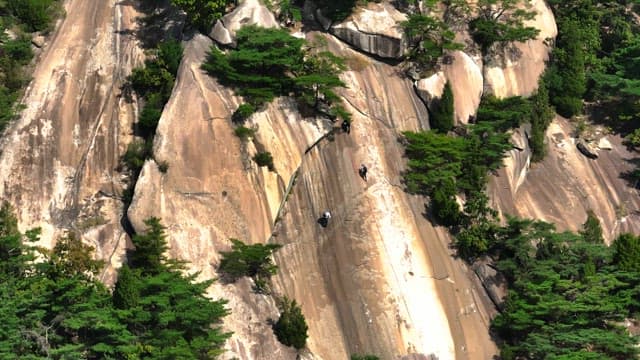 Hikers climbing a rocky mountain slope