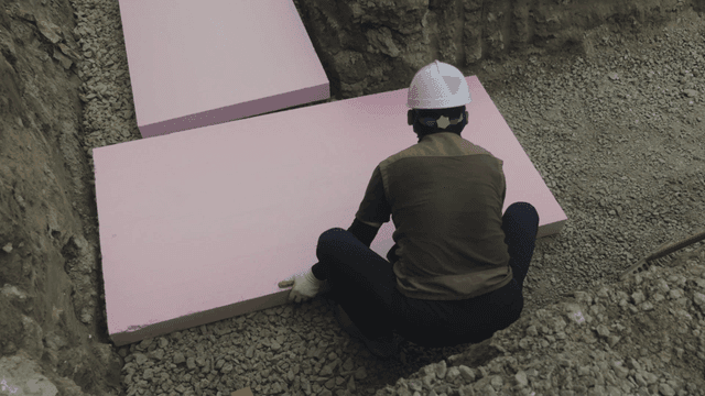 작업자가 분홍색 단열재를 놓는 모습