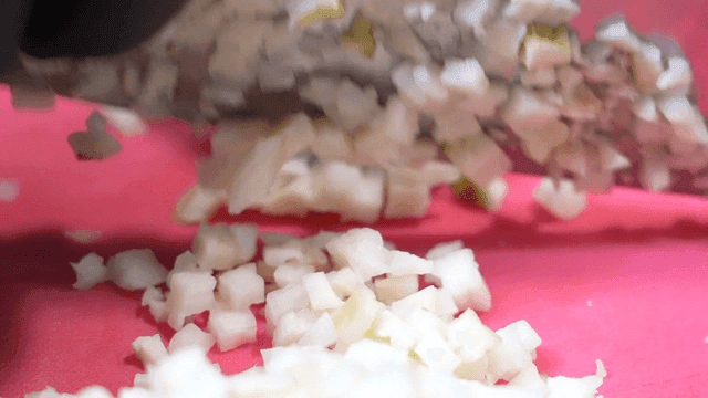 Diced onions being chopped on a board