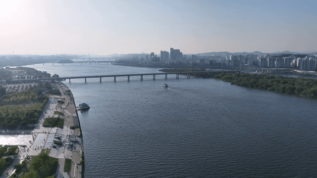 다리와 도시 스카이라인이 있는 강