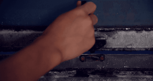 Hand latching a frosty window