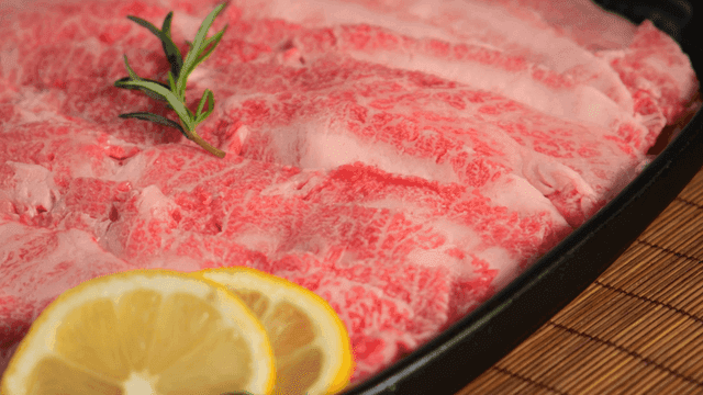 Marbled beef slices with lemon garnish