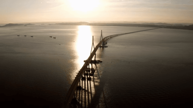 해질녘 잔잔한 바다 위의 긴 다리