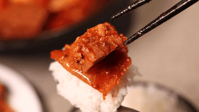 Kimchi and pork on top of white rice
