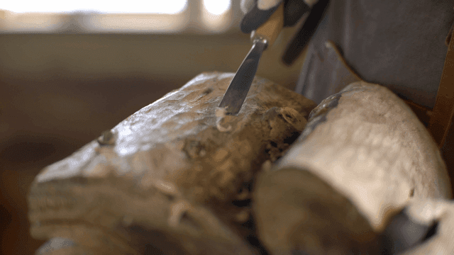 끌로 힘주어 나무를 조각하는 목공예가