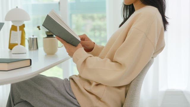 Woman Reading a Book in a Bright Room