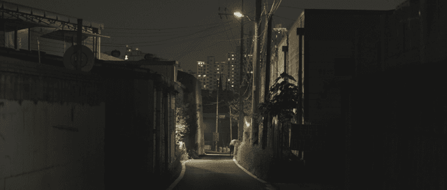 Quiet alleyway at night with city lights