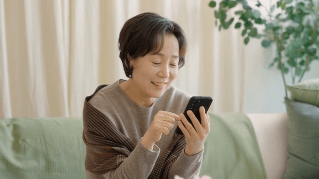 Woman smiling while using a smartphone