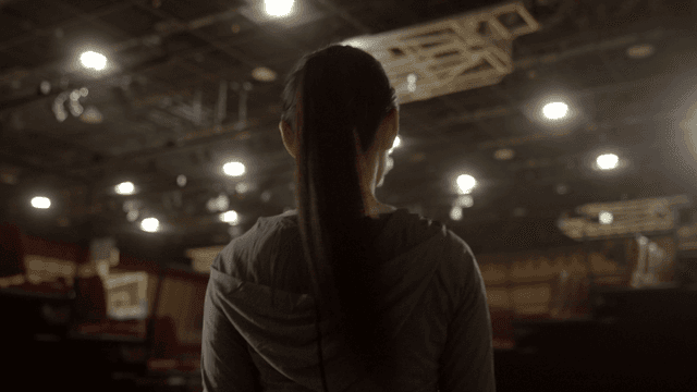 Back view of woman entering bright gym