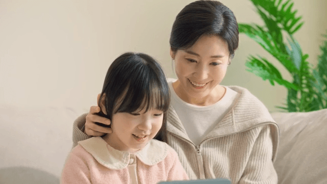 엄마와 딸이 함께 태블릿을 사용하는 모습