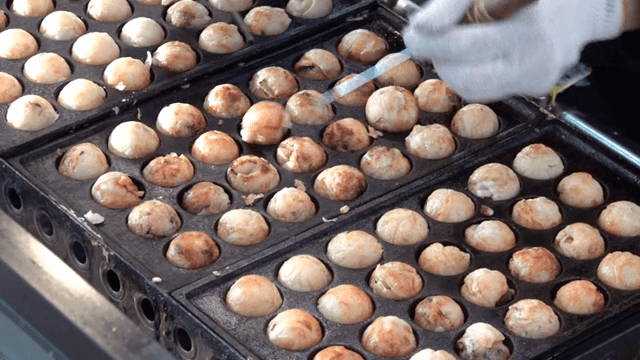 Cooking takoyaki on a hot griddle