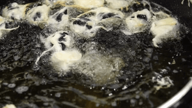 반죽이 묻은 가지를 기름에 튀기는 장면