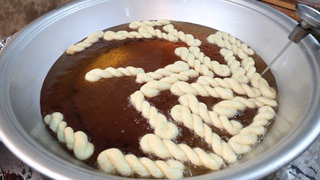 기름에 전통 꽈배기 반죽을 튀기기