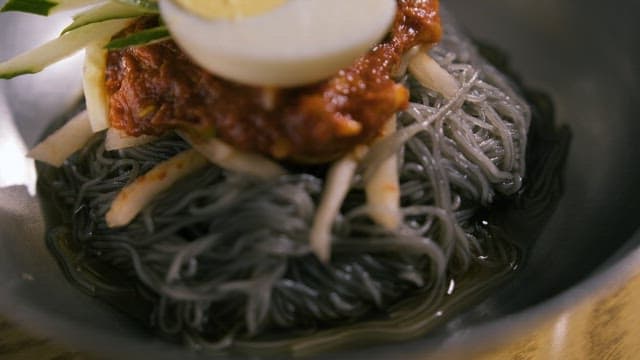 Bowl of Cold Noodles with Toppings of Egg and Sauce