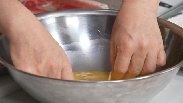 계란물을 입힌 고기를 기름 두른 프라이팬에서 굽는 모습