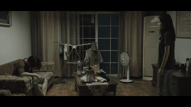 Woman steps on glass in messy living room