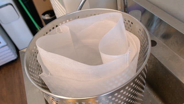 Fabric strainer inside a metal container in a commercial kitchen