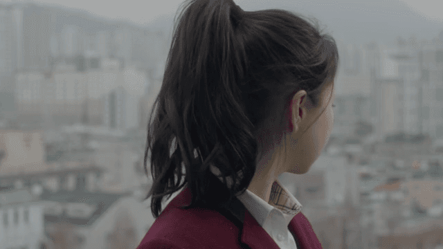 생각이 잠긴 표정으로 도시를 바라보는 학생