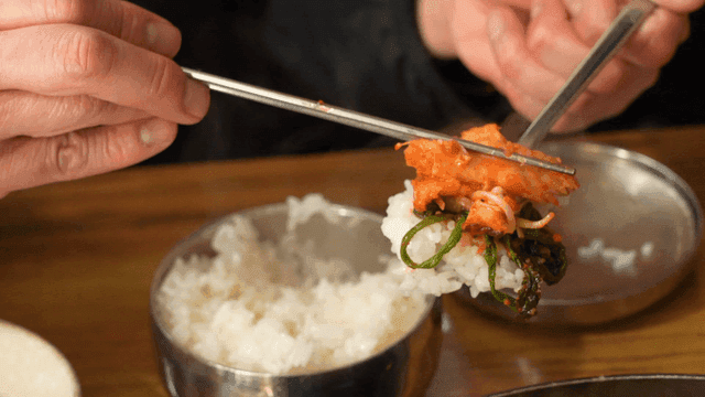 Bokbulgogi placed on top of rice with chopsticks
