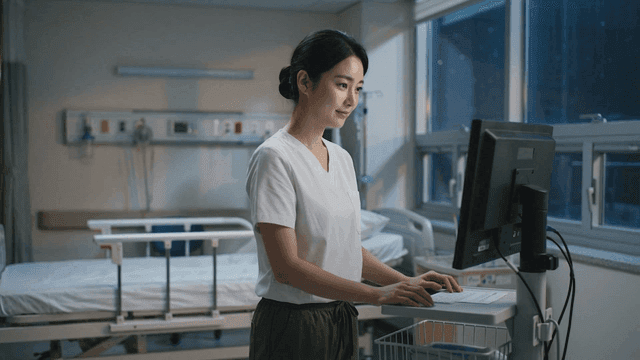 Nurse working on computer in hospital room