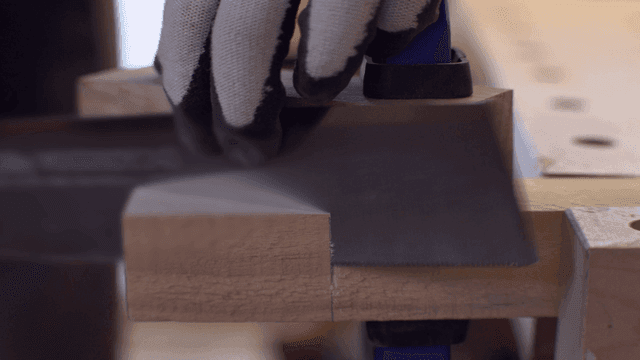 작업실에서 톱으로 나무를 자르는 모습