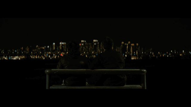 밤에 벤치에 앉아 있는 두 사람