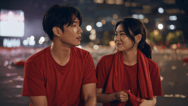 Couple smiling at each other after cheering for soccer game at night