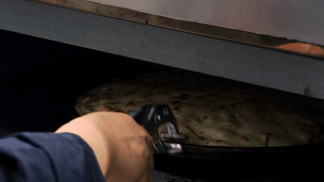 오븐에 피자를 넣는 장면