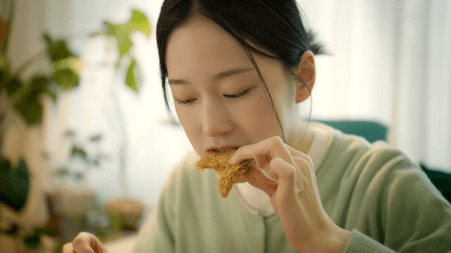 Woman eating crispy chicken at home