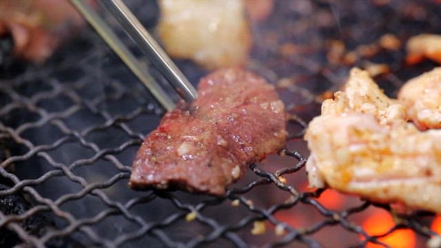 Grilled beef heart picked up with chopsticks