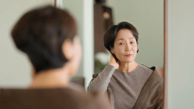 실내에서 거울을 보는 여성