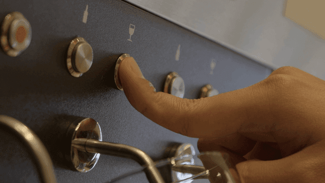 Finger pressing wine machine button