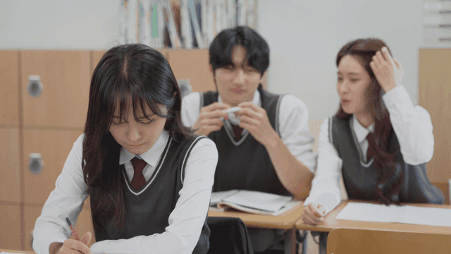 Two students laughing in the back and a front student with a stiff expression