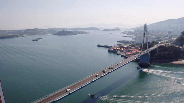 Bridge over a calm sea with cityscape