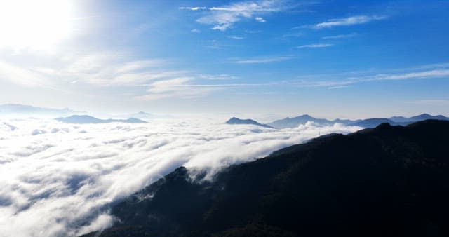 Mountains covered with clouds under a blue sky