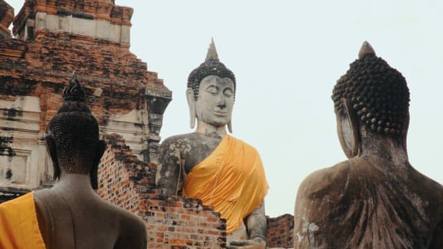 Three Buddha statues in a Thai temple built of bricks