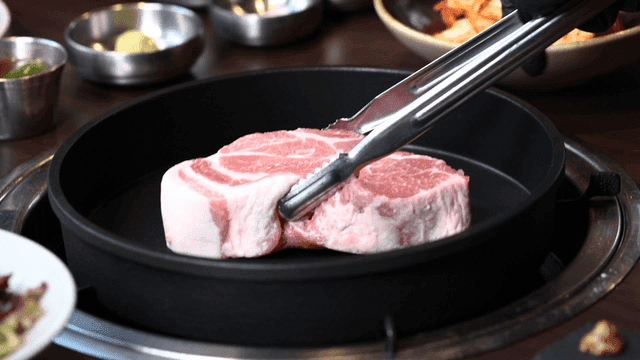 Tongs for placing raw pork on grill