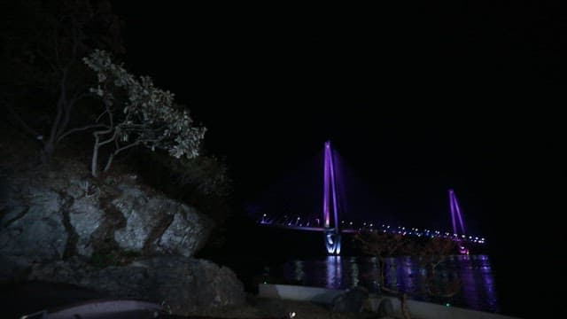 Night camping near a lit bridge