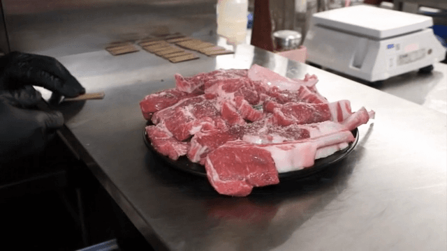 Raw meat being prepared in a kitchen