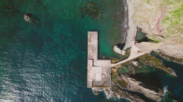 Rocky coastline with a small pier