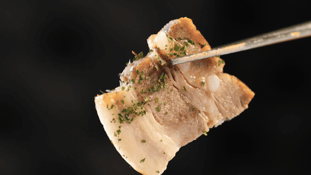 Piece of bossam pork picked up with chopsticks