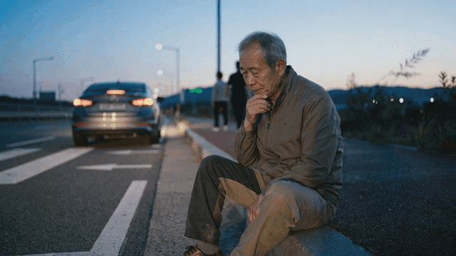 Old man sitting by roadside
